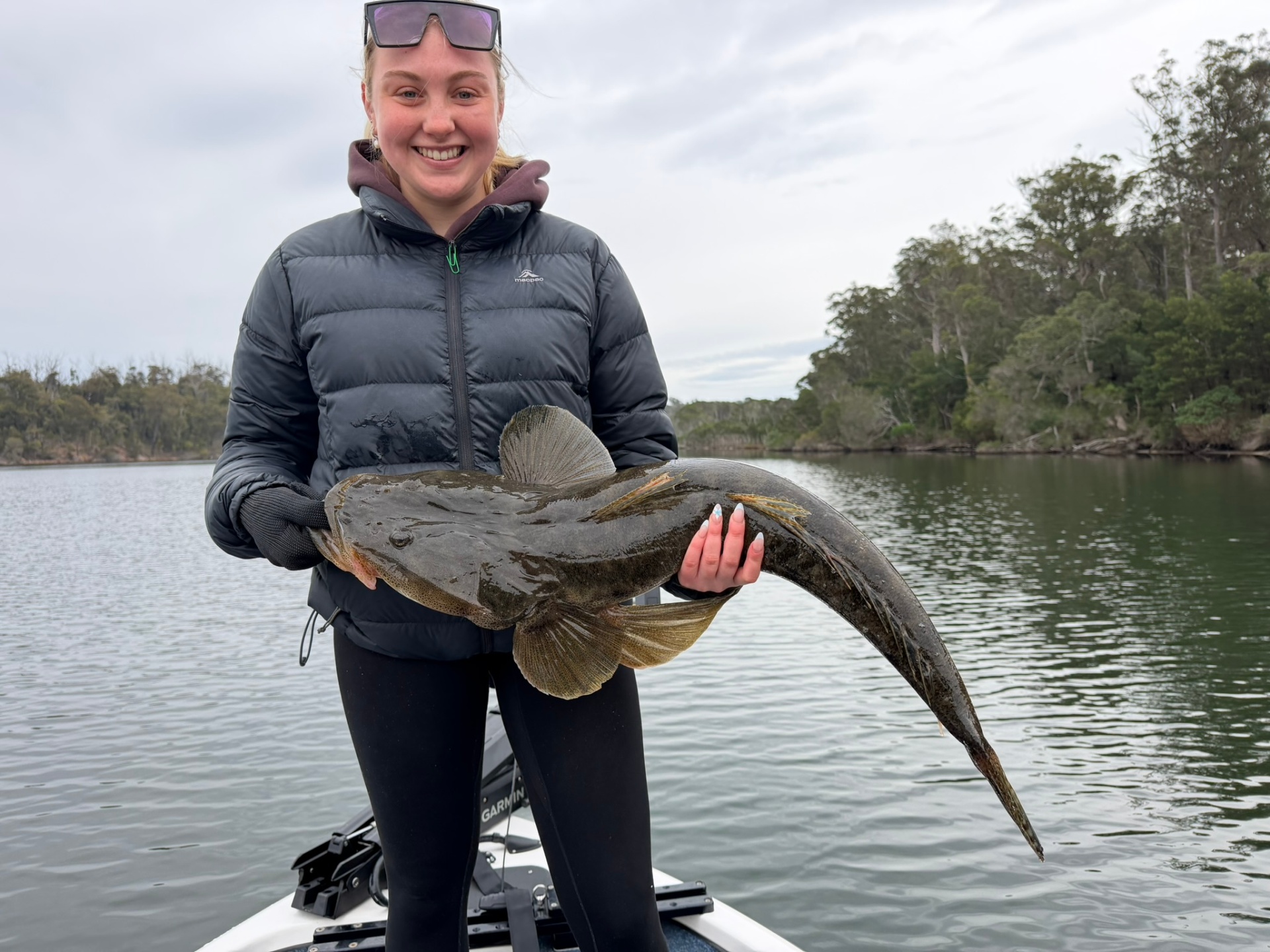 A guest holding a large dusky flathead caught on a private guided charter